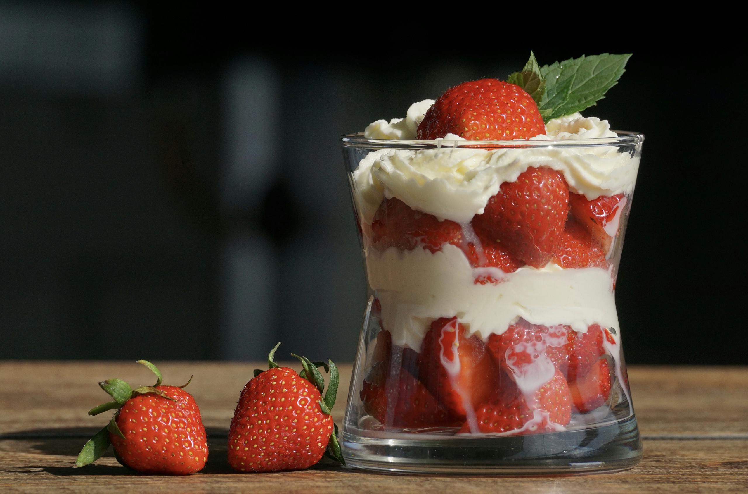 Delicious strawberry dessert layered with cream in a glass, perfect for a summer treat.